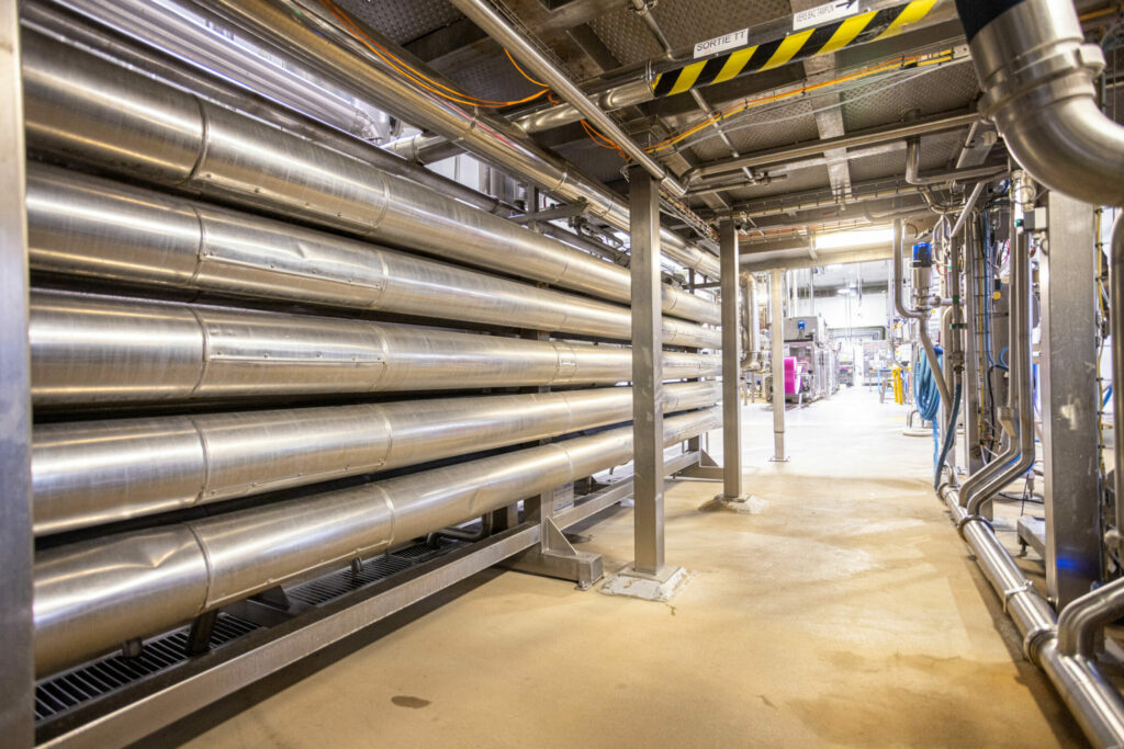 photo de l'intérieur d'une usine d'agroalimentaire, vue sur des conduits en inox.