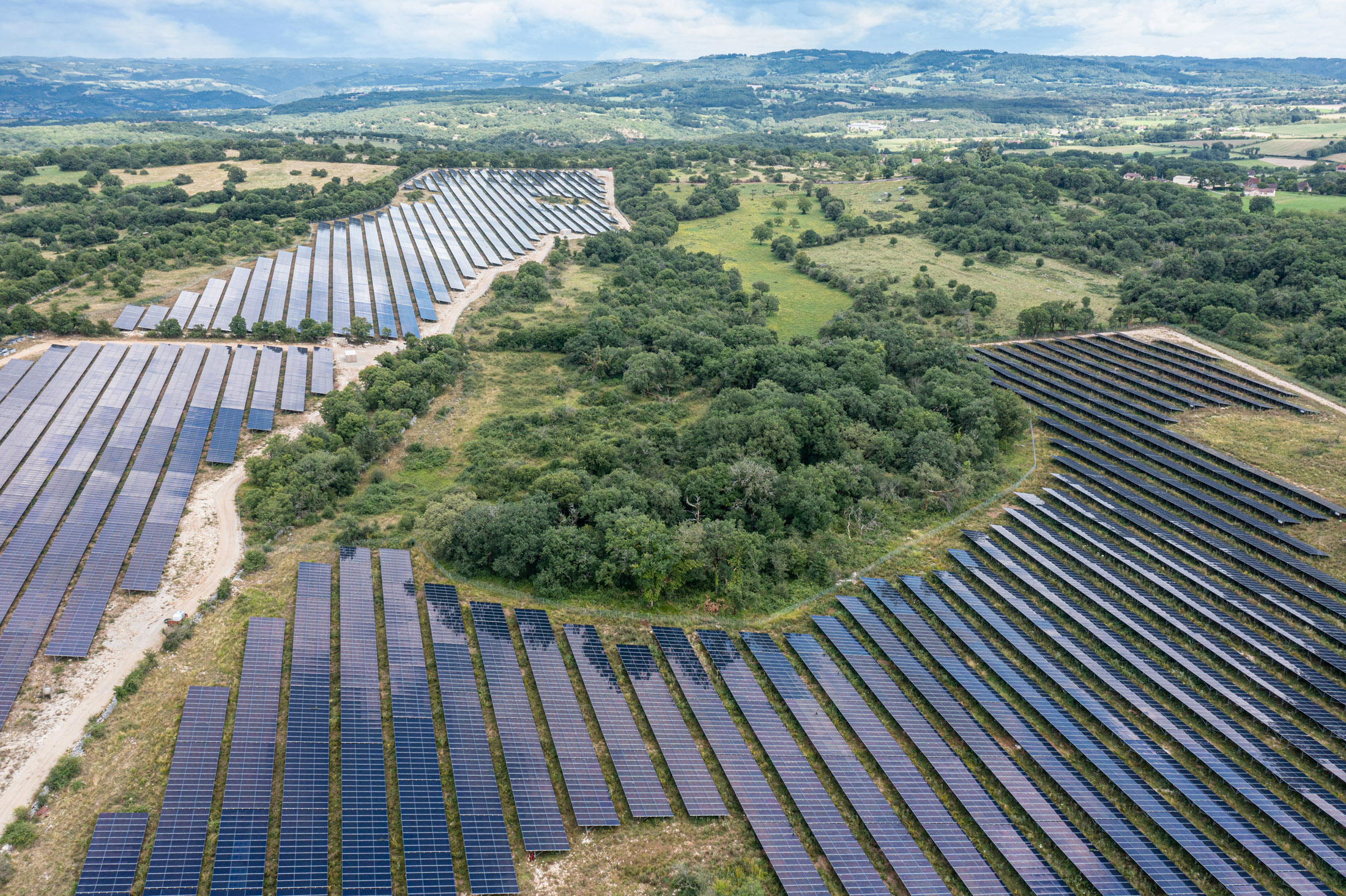 Photo aérienne d'un parc de panneaux photovoltaiques dans un environnement vert de campagne des causses du Lot